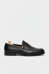 Black textured leather slip-on loafer with elegant design and comfortable fit.
